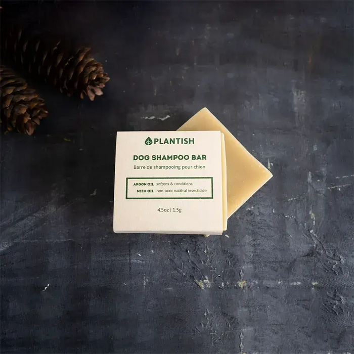 Dog shampoo bar with a cardboard wrapper on a dark gray background