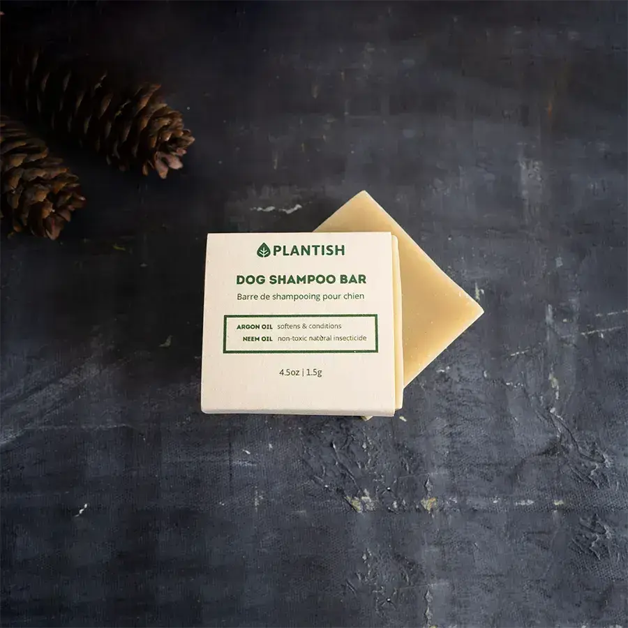 Dog shampoo bar with a cardboard wrapper on a dark gray background