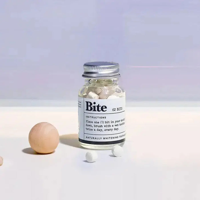 Bottle of 'Bite' toothpaste with a brown egg on a light background