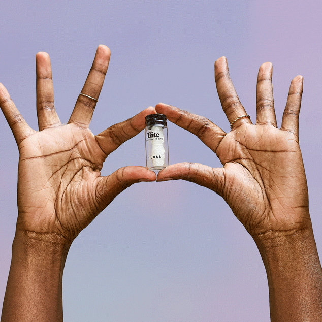 Hands holding floss fingers extending the floss from its package