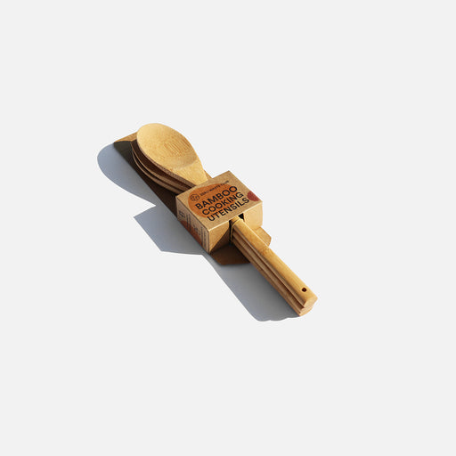 A wooden spoon and fork resting on a clean white surface, showcasing their natural texture and craftsmanship.