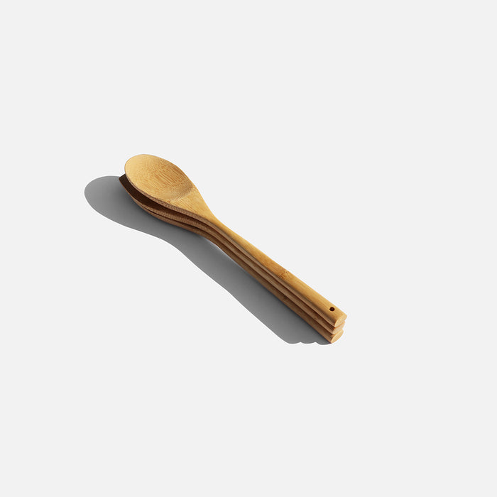 A wooden spoon and fork placed on a white background, highlighting the simplicity and elegance of cooking utensils.
