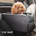 Dog sitting in a gray pet car seat inside a vehicle