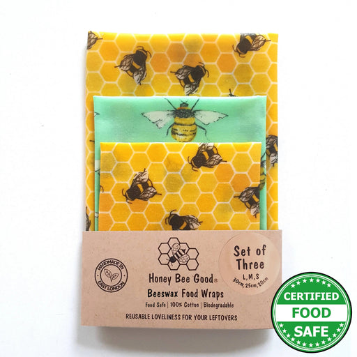 Set of three beeswax food wraps with honeycomb and bee pattern on a white background
