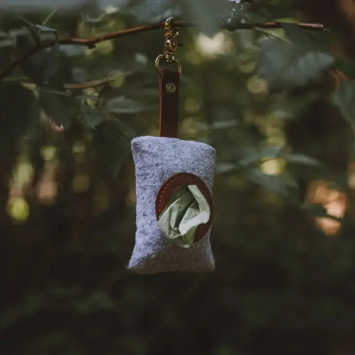 Small pouch with a green leafy vegetable hanging from a branch