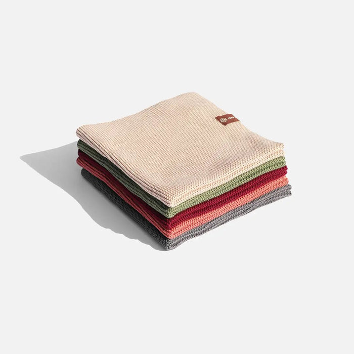 Stack of folded towels in various colors on a light gray background