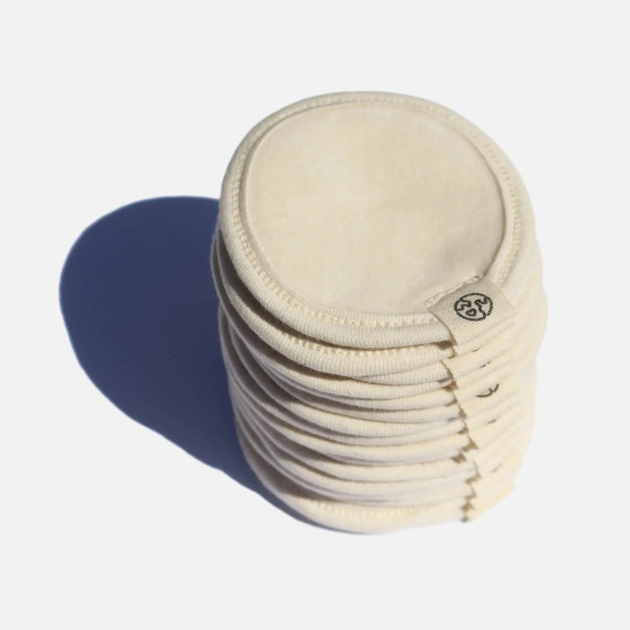 Stack of beige reusable pads with a brand logo on a white background