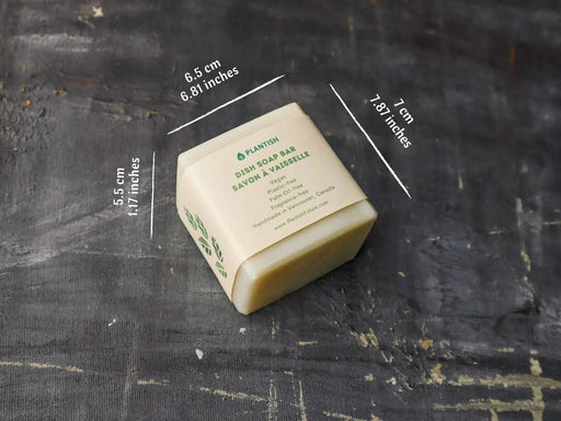 Bar of soap with dimensions labeled on a dark textured surface