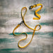 Yellow dog leash with black buckle on a textured gray background